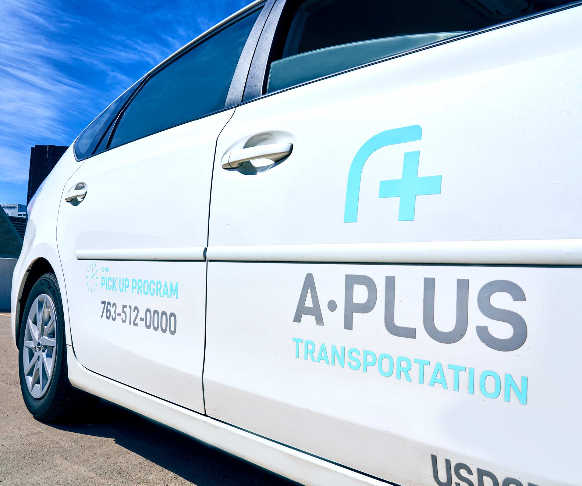 A close-up of the A-Plus Transportation logo vehicle graphics.