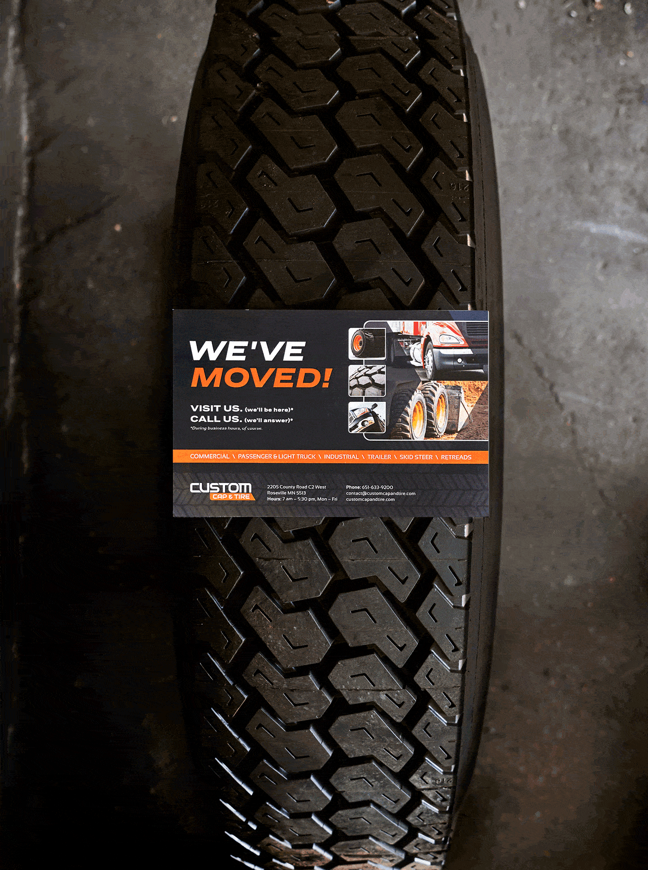 The front and back of the We've Moved postcard on a tire.