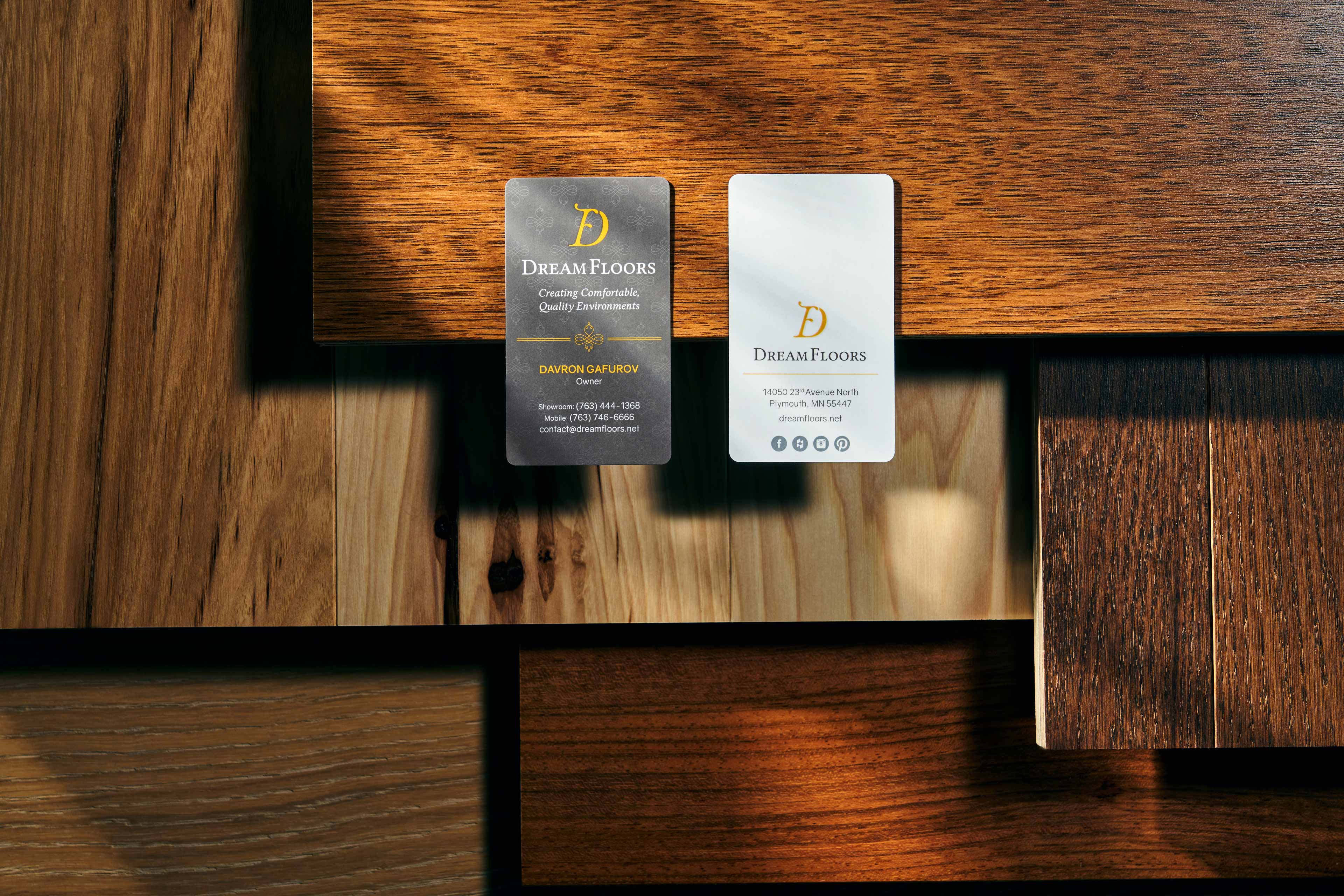 Dream Floors business cards sit on various flooring options.