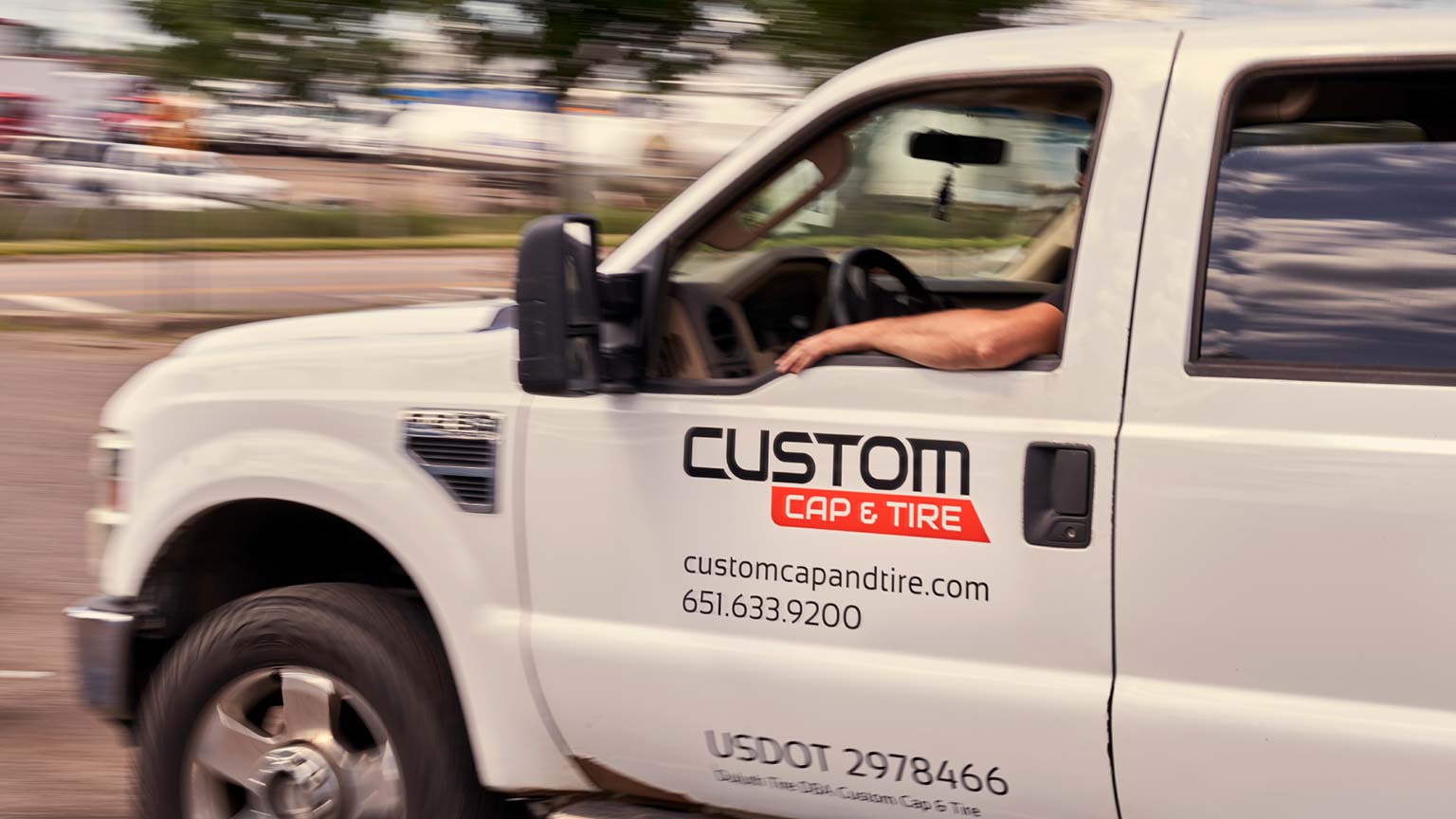 The Custom Cap and Tire logo on the side of a truck.